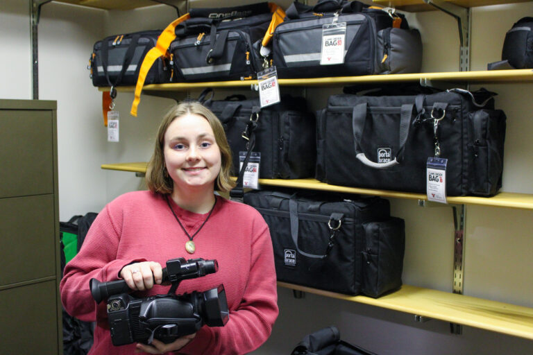 YSU Journalism and Content Creation student in the equipment room.