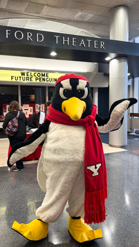 Pete the Penguin standing in front of Ford Theater waving, sign on the marquee behind Pete says "Welcome Future Penguins"